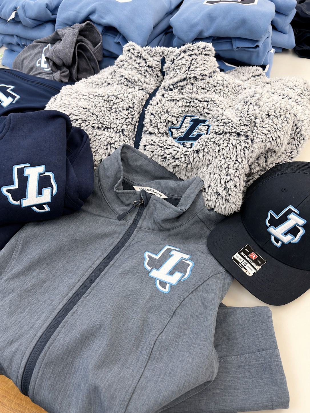 A shirt, sweater, vest and hat with the same team logo on them